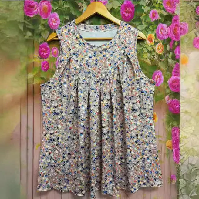 Black floral print sleeveless vest on hanger showing round neck and loose fit design