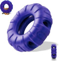 Blue tyre-shaped dog chew toy with oval openings for treat dispensing on a wooden floor.