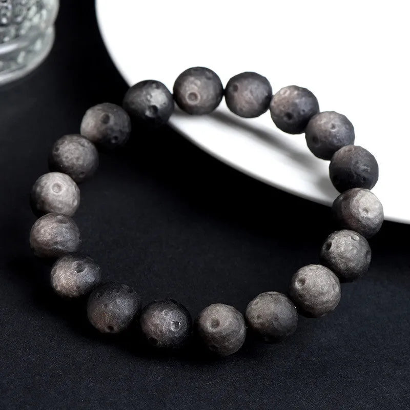 Natural obsidian crater ball bracelet with polished beads in silver or golden meteorite colours