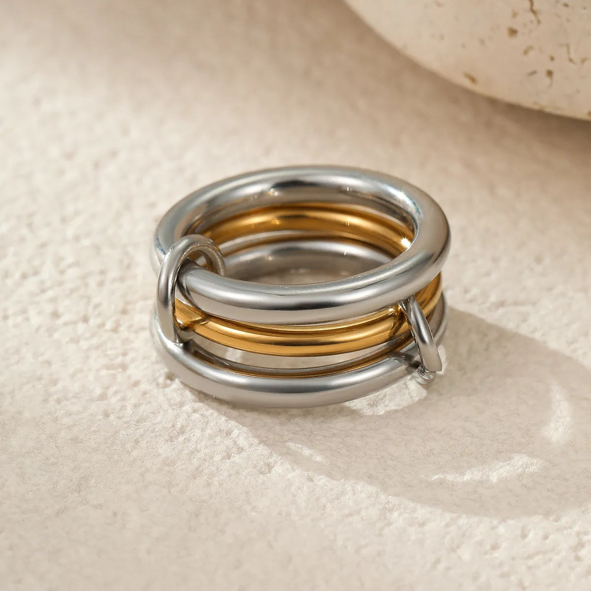 Stacked gold plated stainless steel rings showing layered jewellery look on female hand