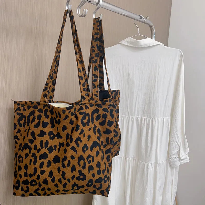 Length adjustable canvas shoulder bag in vintage leopard print with zipper closure