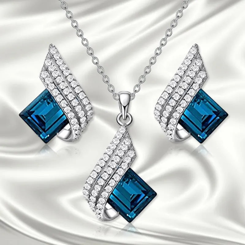 Glass pendant on an alloy cross chain necklace with matching ear studs, in two colour style options.