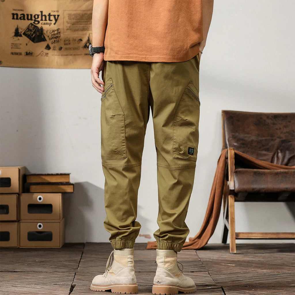 Men's loose fit cotton trousers with tapered ankle banded legs in khaki colour.