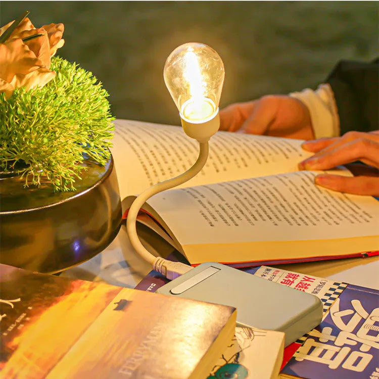 USB rechargeable folding night light with a glowing tungsten filament bulb on a table.
