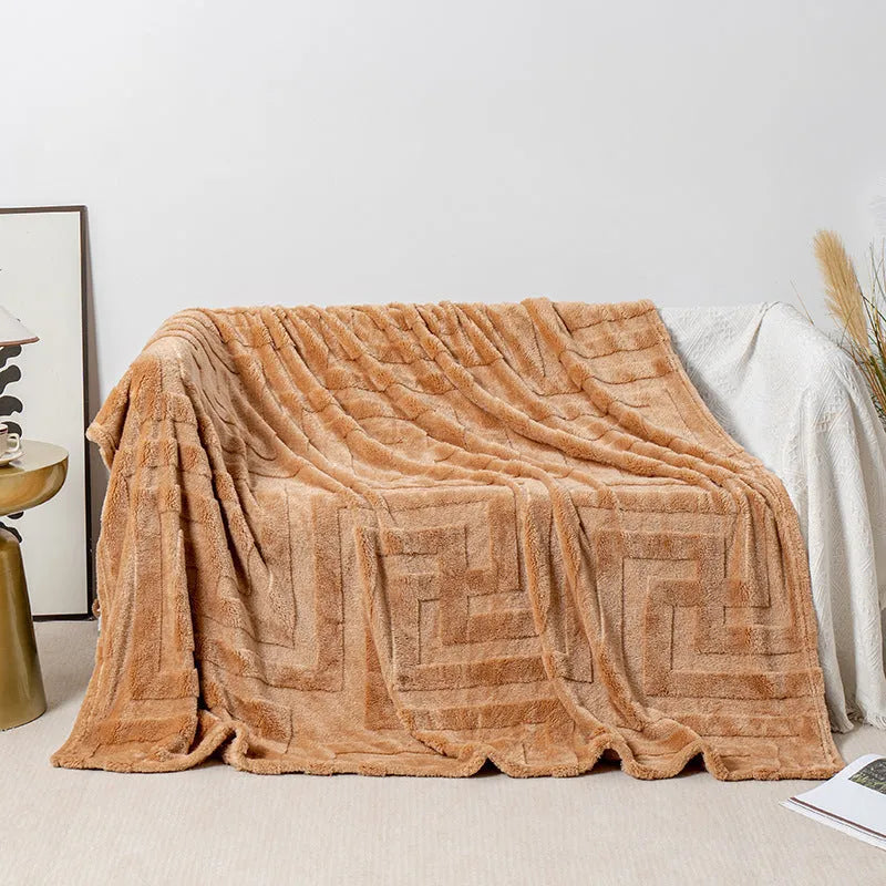 Thick square coral fleece blanket in a solid colour, draped over a sofa.