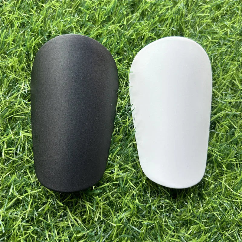 Extra small mini football shin guards in black and white colours measuring 8cm by 5cm