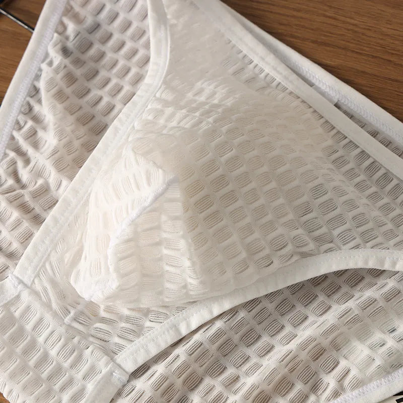 Men's low waist transparent lace underwear shorts in a solid colour on a neutral background.
