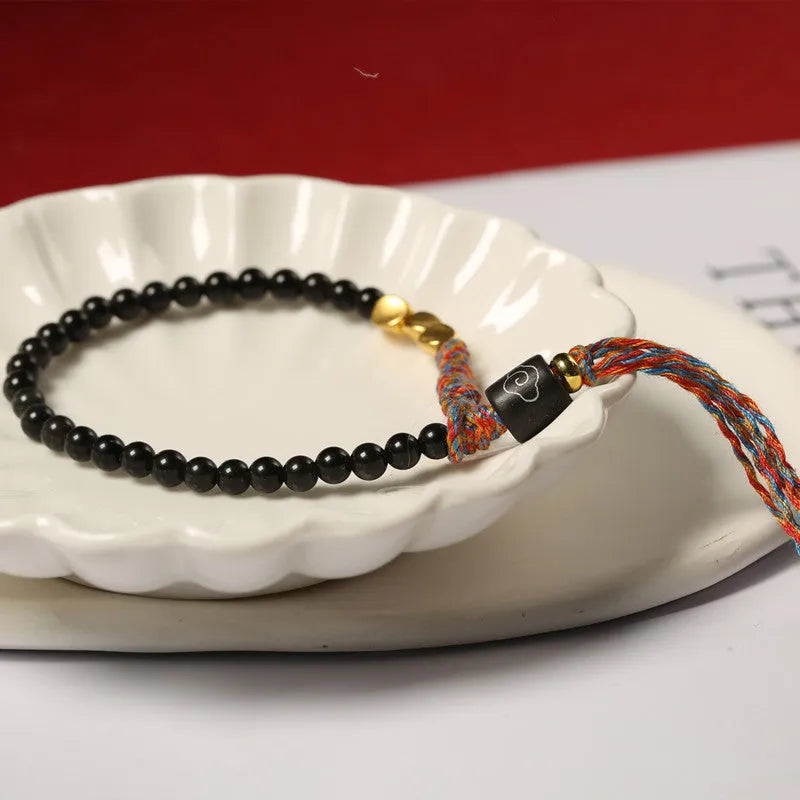 Hand-woven obsidian carrying strap bracelet showing textured surface and 4mm width