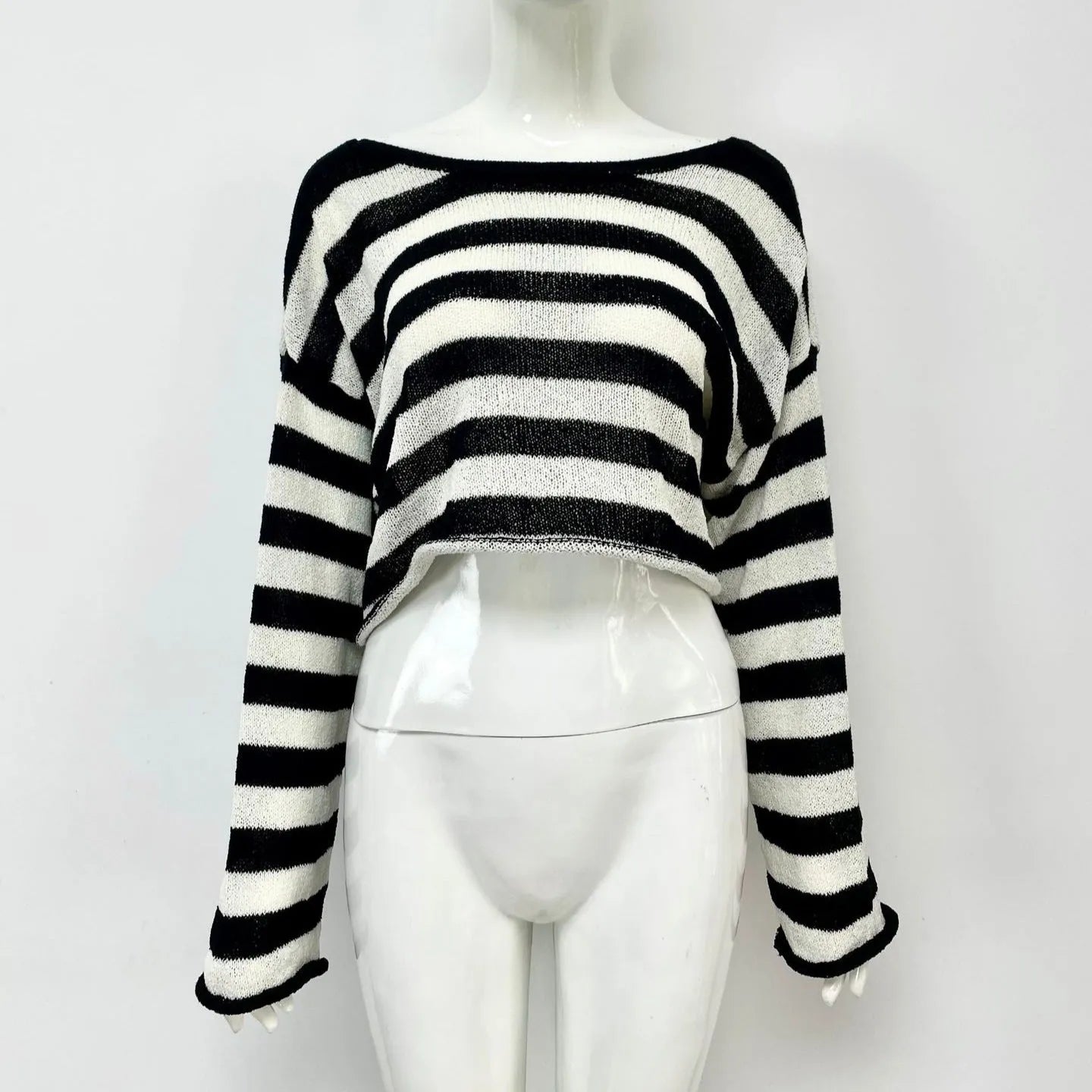 Woman wearing a striped long-sleeved cropped sweater in mercerised cotton, showcasing front and back wearable design.