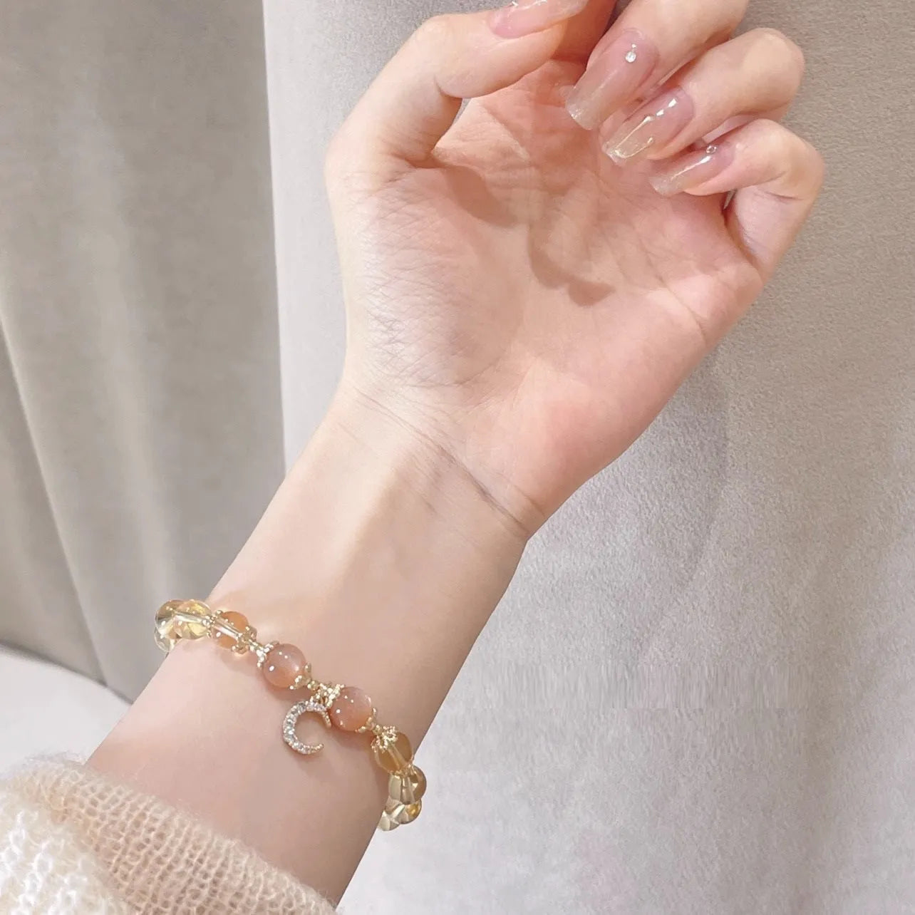 Women's crystal bracelet with moonstone and golden sun stone centrepiece, 14K gilded electroplated links, Chinese diamond-shaped style.