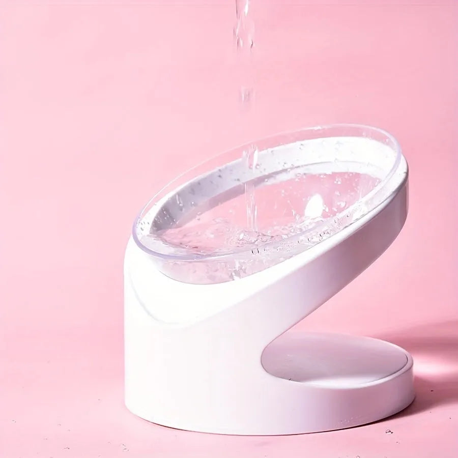 White clear plastic elevated cat food bowl with tilted anti-vomit design on a raised stand.