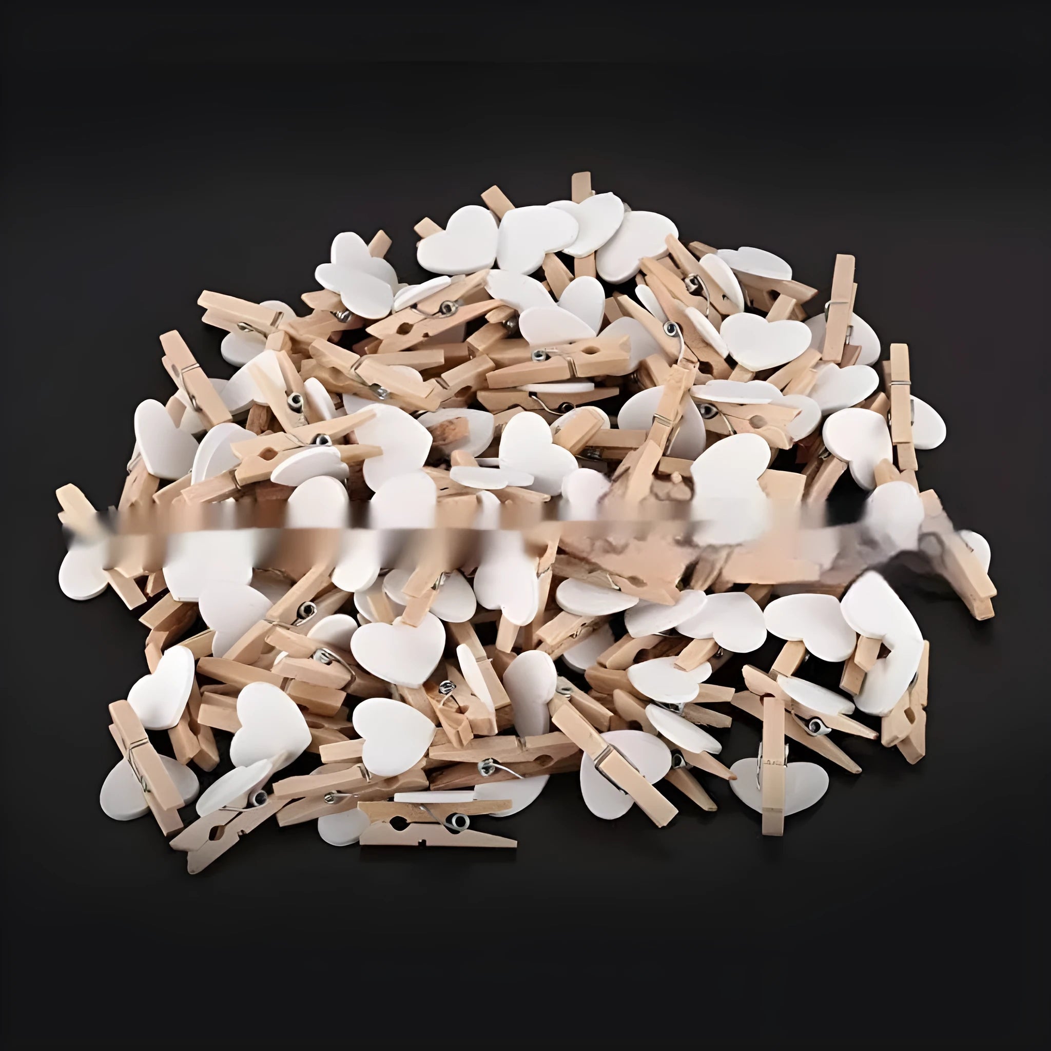 Set of five solid wood heart-shaped clips in different colours on wooden surface