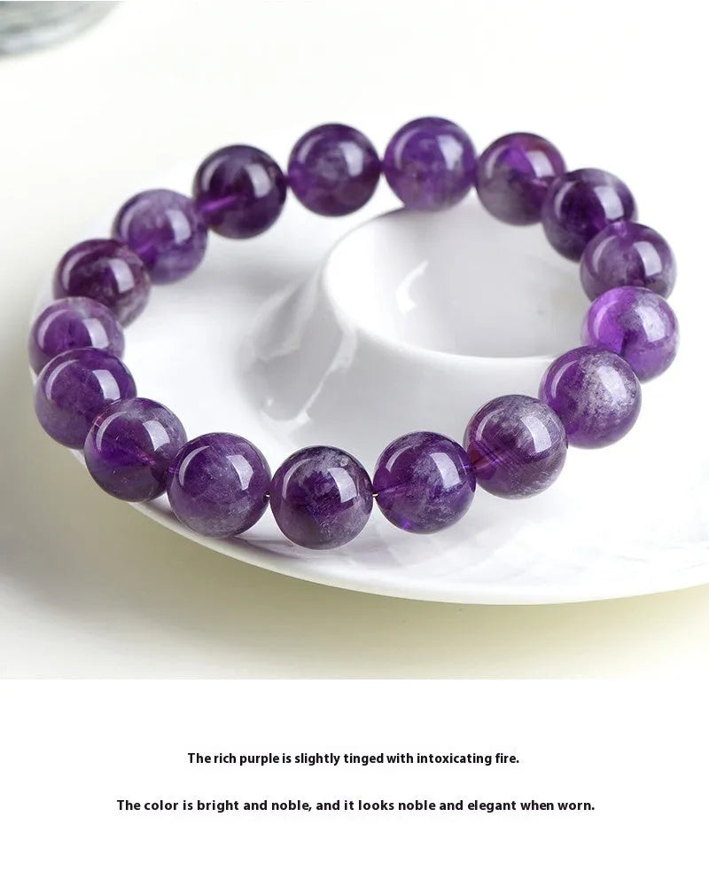 Natural Feather Amethyst crystal bracelet with Ruyi charm beads on a wrist.
