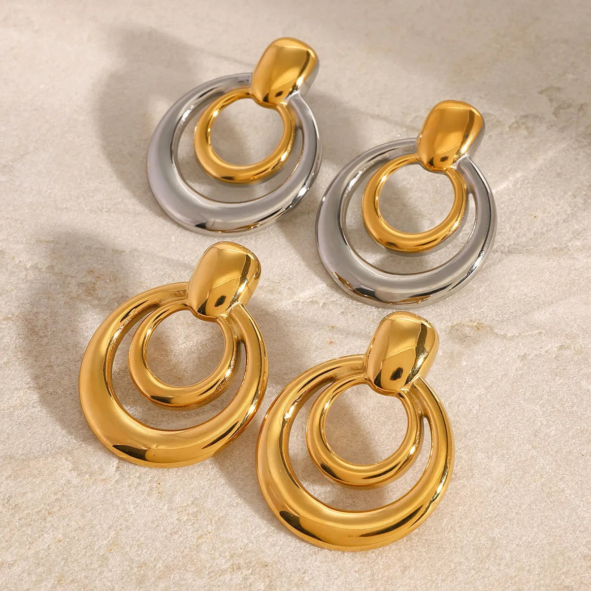 Golden round double layer hollow stud earrings with 18K gold electroplating on titanium steel