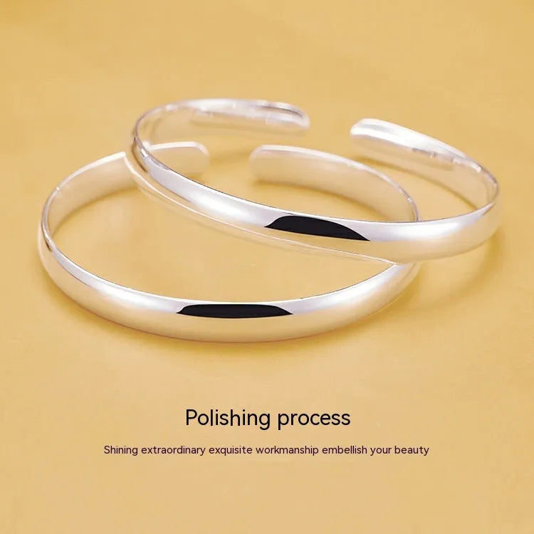 Glossy silver-plated copper bracelet with Ruyi and lucky cat charms on white background