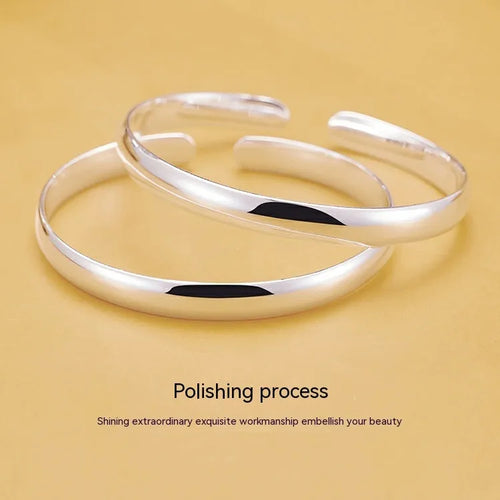 Glossy silver-plated copper bracelet with Ruyi and lucky cat charms on white background