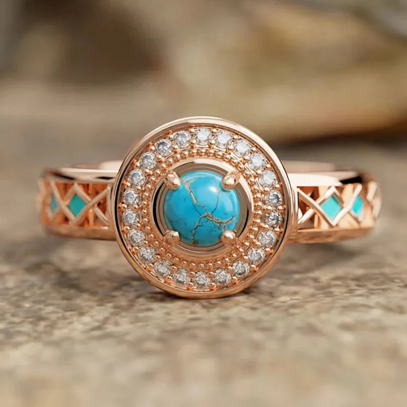 Women's rose gold copper ring with geometric design and inlaid turquoise-style zircon stones.