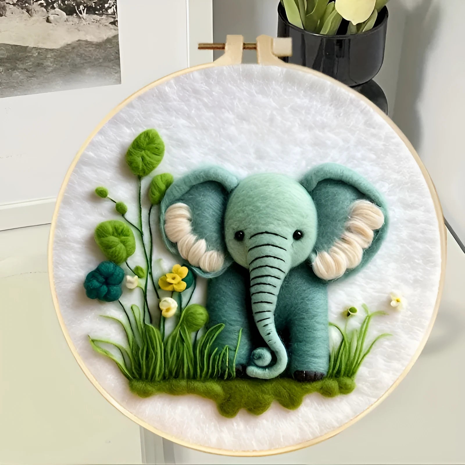 Round 20x20 cm linen embroidery kit with wool felt pieces for floral design and included embroidery frame.