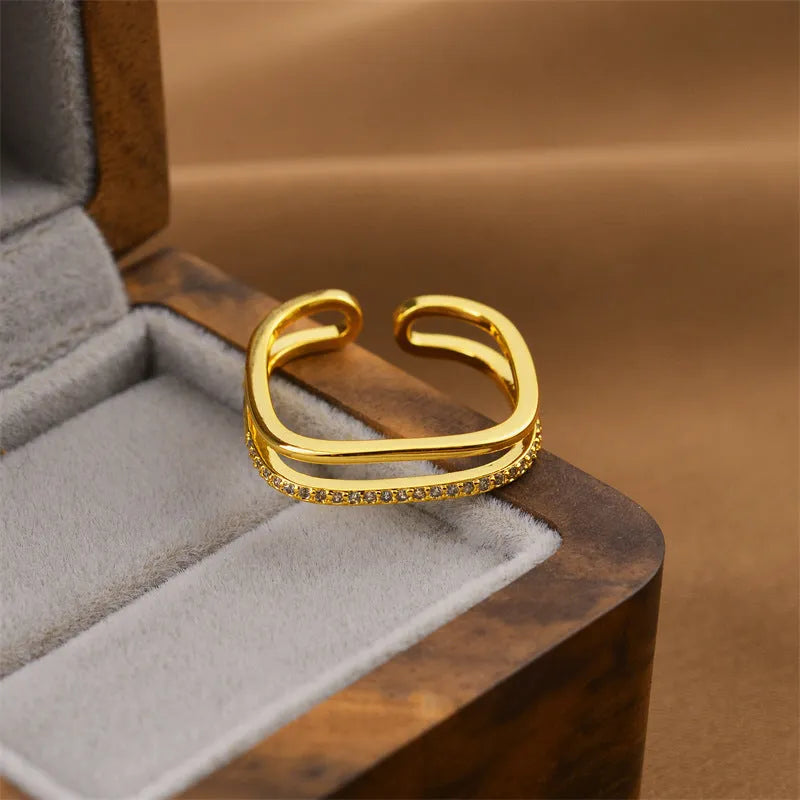Gold tone geometric open back fashion ring on a hand, showing its adjustable design.