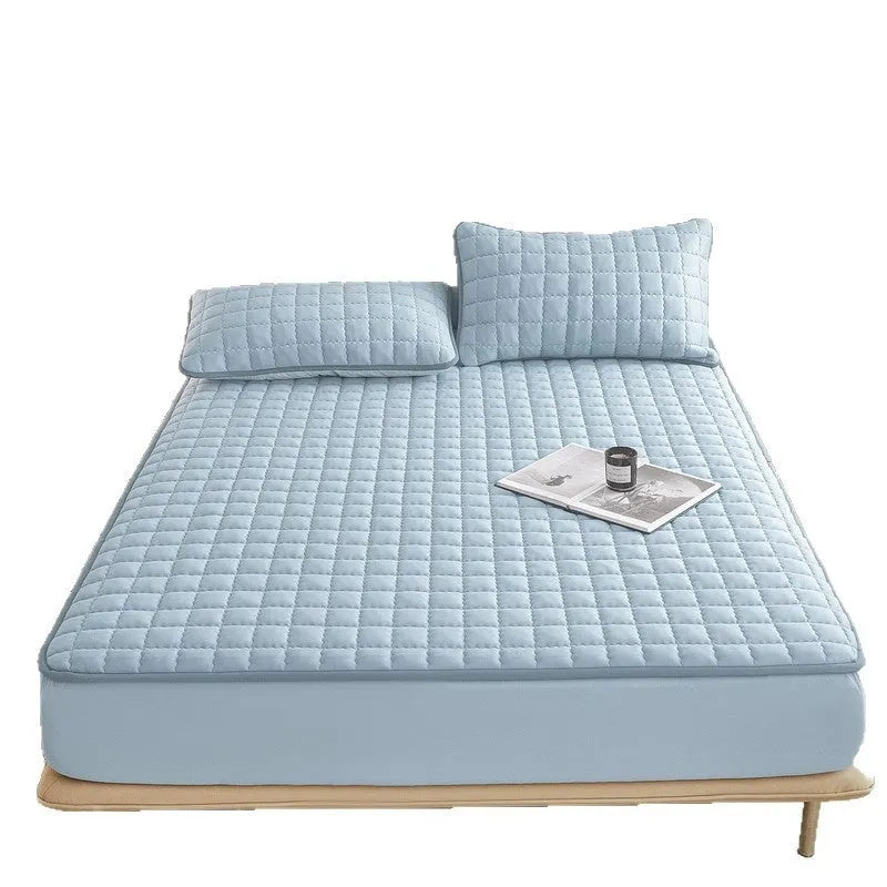 Blue washed cotton fitted sheet with quilted pattern on a bed, showcasing its waterproof protection feature.