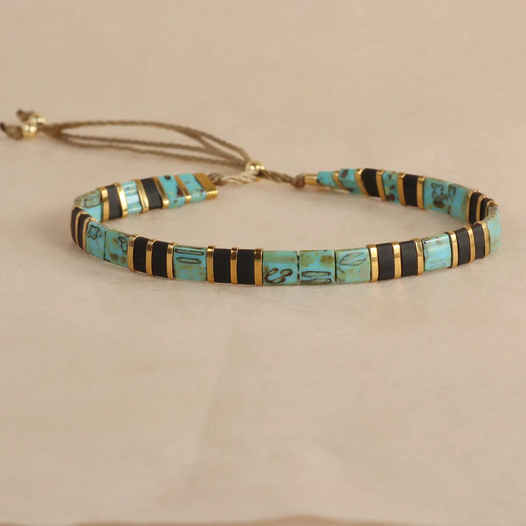Geometric pull bead bracelet in milky white glass beads on a wrist.