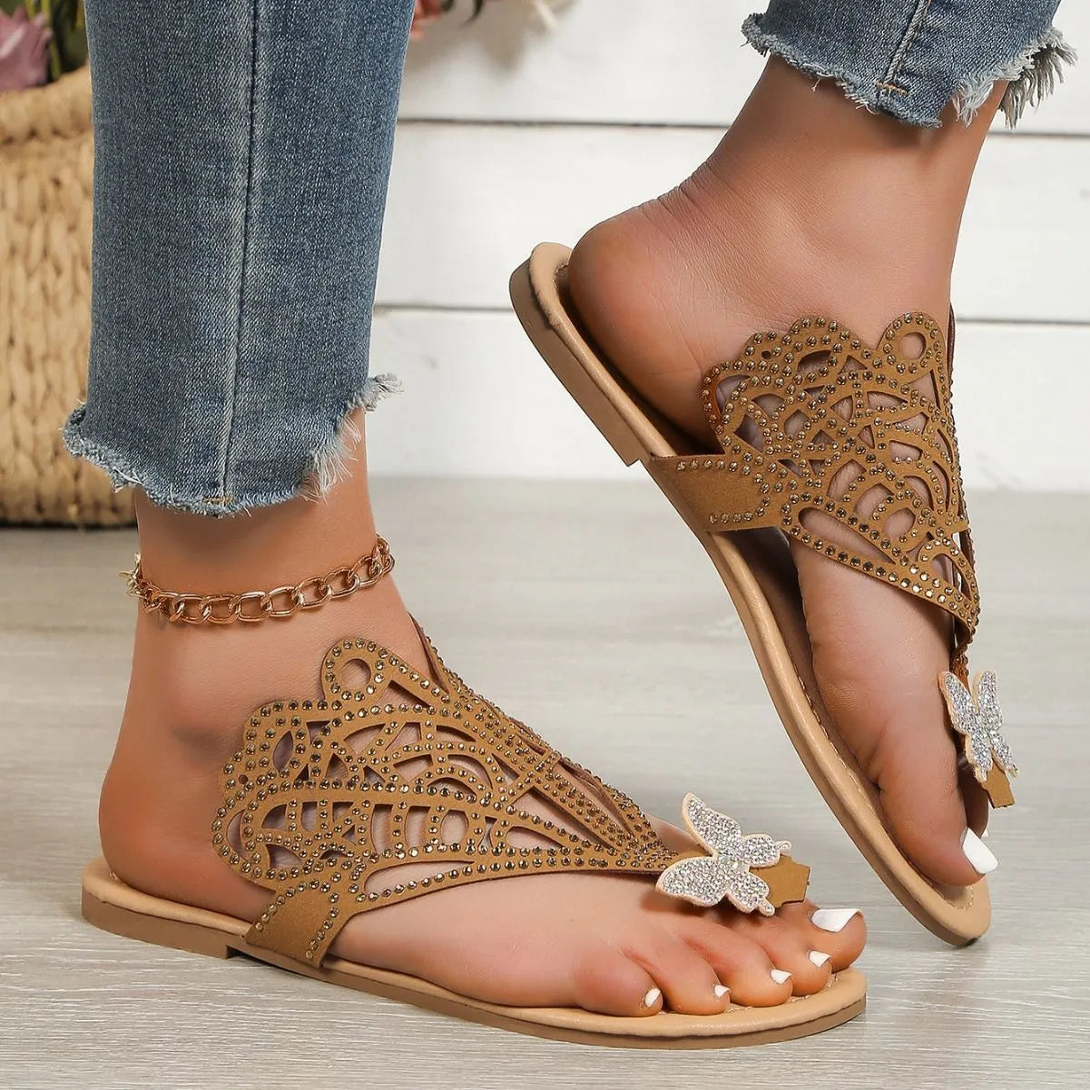 Women's black slip-on sandals with rhinestone detail, hollow-out design, and flat rubber sole.