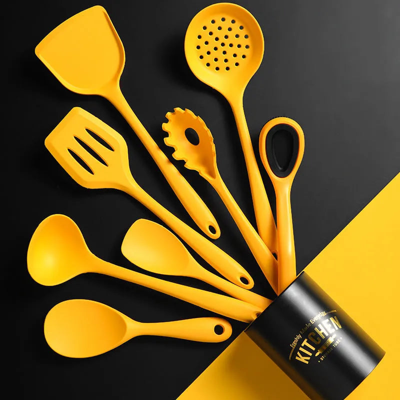Yellow nonstick silicone and nylon cooking spoon and spatula set on a light background
