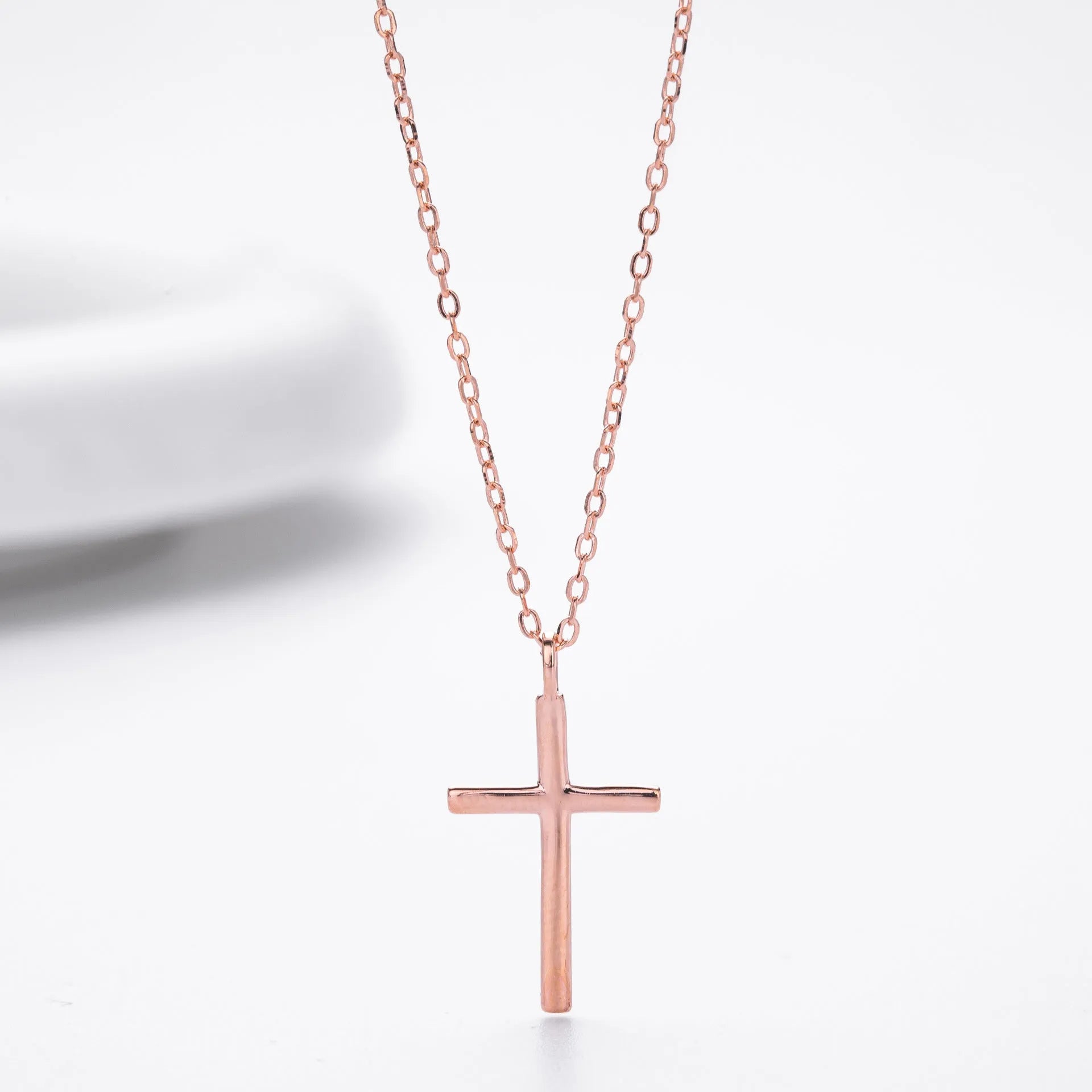 Simple sterling silver cross pendant necklace with glossy finish on adjustable O-link chain