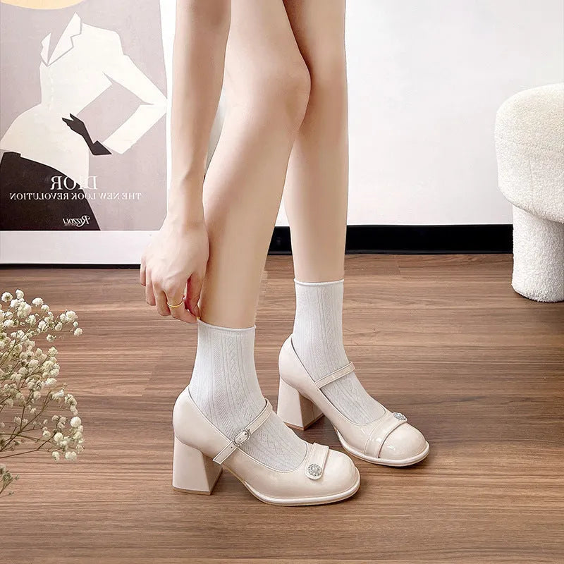 Women's apricot patent leather high heels with a round toe and chunky heel, shown with a buckle fastening.