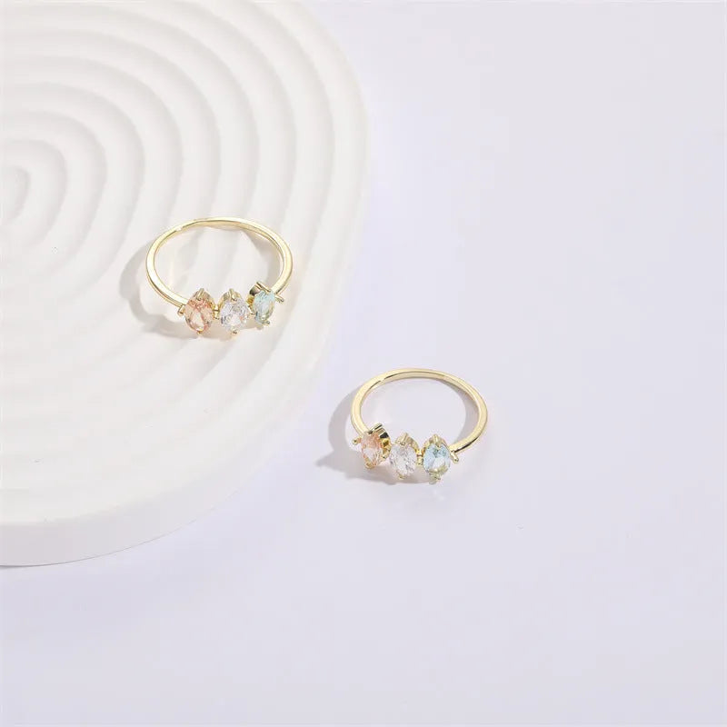 Geometric birthstone ring with horse eye shaped tricolor zircon stones in gold colour