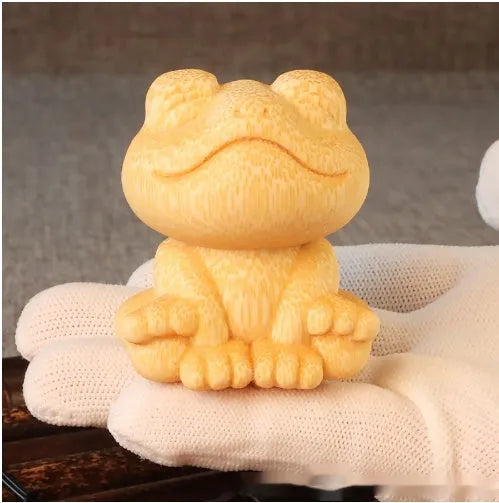 Solid bamboo carving of a cartoon smiling frog ornament, 5cm tall.
