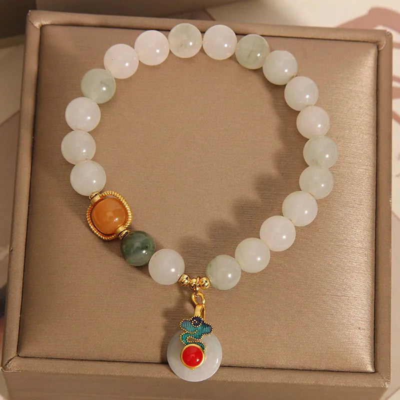 Close-up of a women's ice jade bracelet with a peace jade buckle and pearl decorative elements.