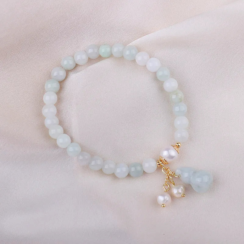 Emerald green jade bracelet with hand-carved gourd charm and pearl decoration in Chinese style