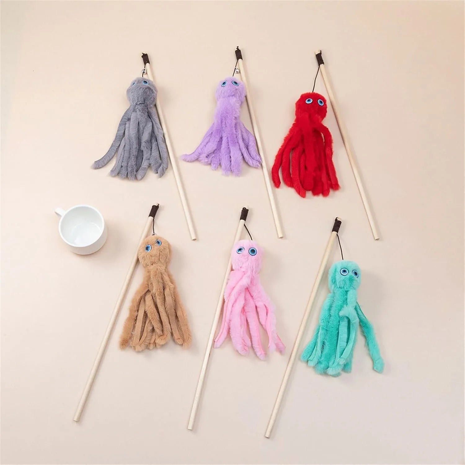 Grey furry octopus cat toy with eyes on a long stick for interactive indoor play with kittens.