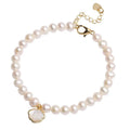 Women's freshwater pearl bracelet with fan-shaped charm on wrist, showing elastic and chain fastening options.