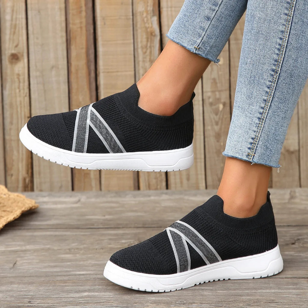Black women's low-top flyknit mesh shoes with flat rubber sole and tassel detail.