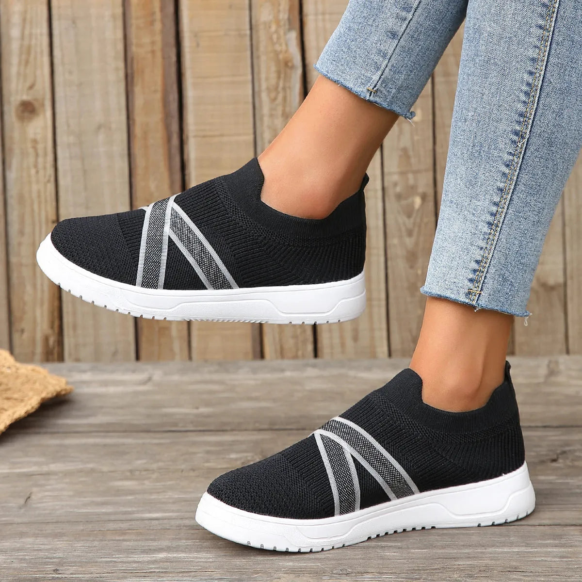 Black women's low-top flyknit mesh shoes with flat rubber sole and tassel detail.