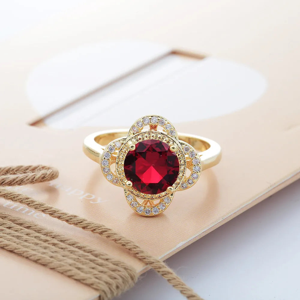 Copper zircon ring with a fruit-shaped design on a finger.