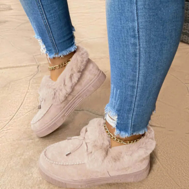 Womens white cotton slip-on shoes with round toe and non-slip rubber sole on a wooden floor.
