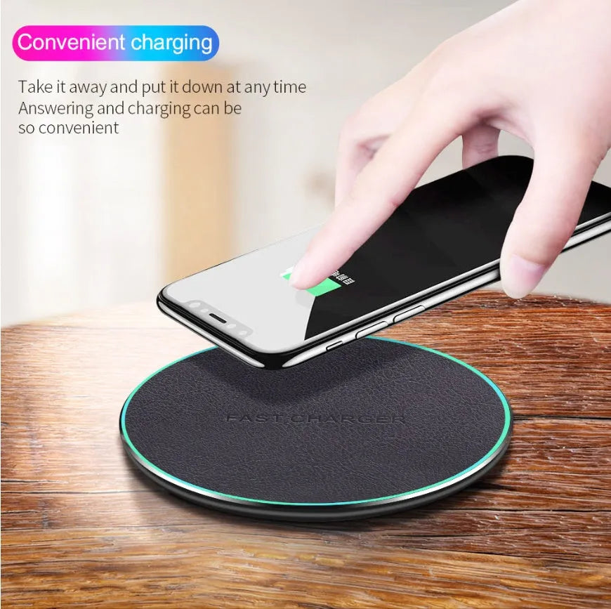 Black Qi wireless fast charging pad for iPhone 11 on a wooden surface.