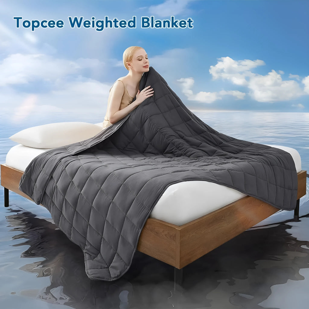Polyester gravity blanket in solid light grey on bed, 152x203cm size, 12 lb weight option