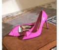 Pink patent leather women's pointed toe stiletto high heels with a buckle detail on the upper.