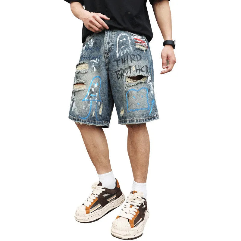 Blue men's denim shorts with ripped knees and graffiti detailing, showing straight leg cut and zipper fly.