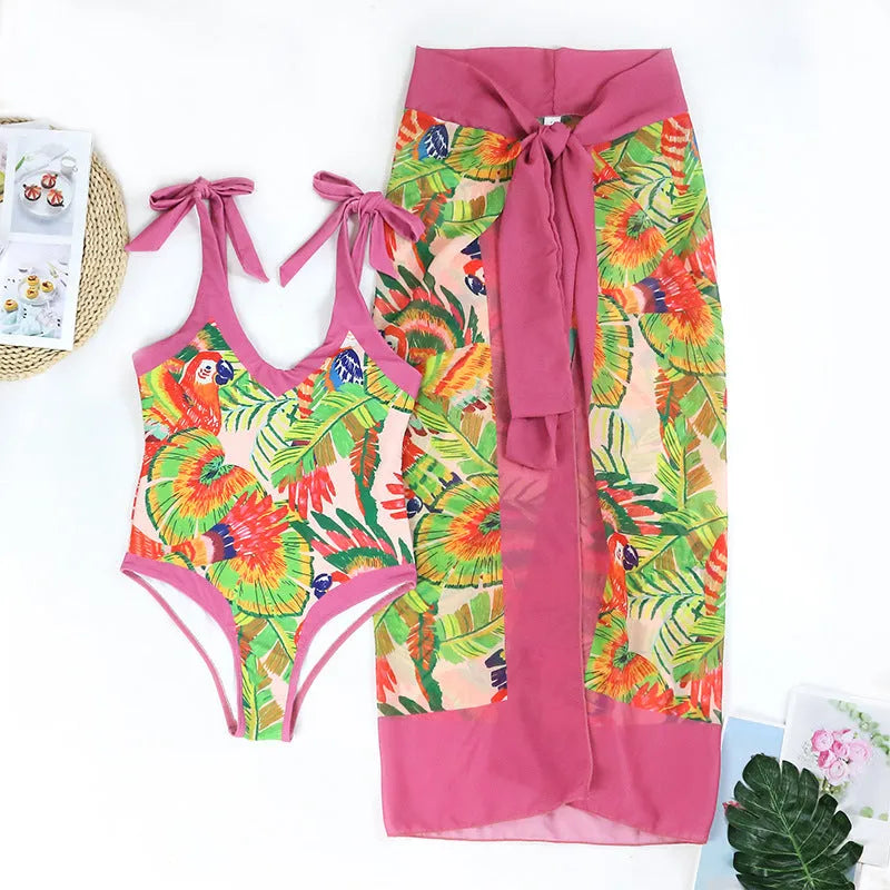 Women's pink floral print one-piece swimsuit with v-neck, covered belly, and attached thin skirt.