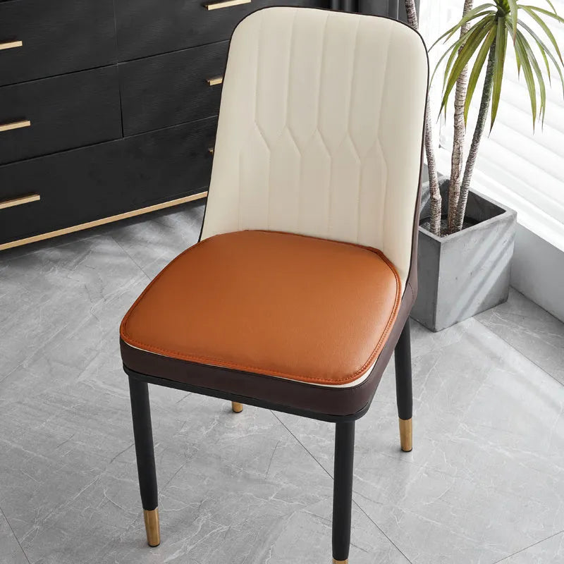 Leather horseshoe-shaped seat cushion in beige colour on a wooden chair, showing non-slip base