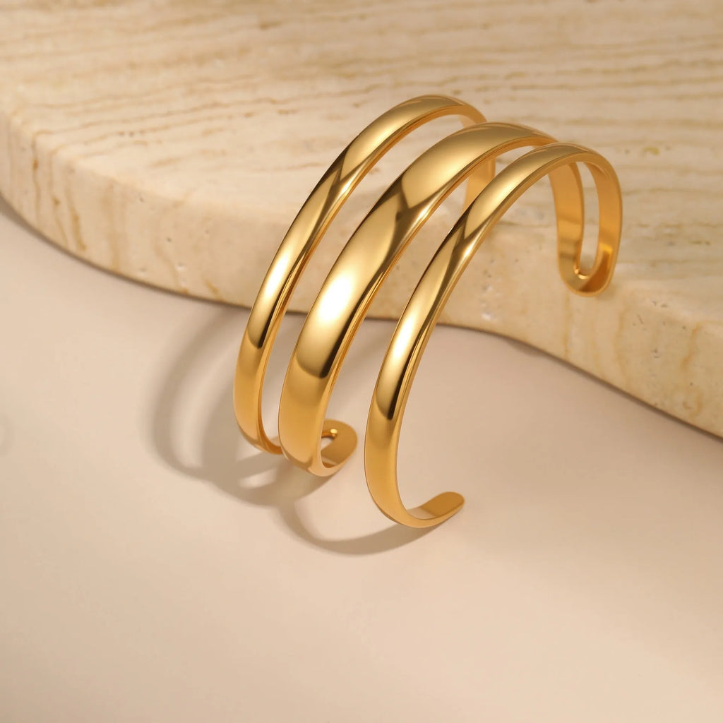 A geometric stainless steel bracelet with a simple opening clasp, shown in a gold electroplated finish.