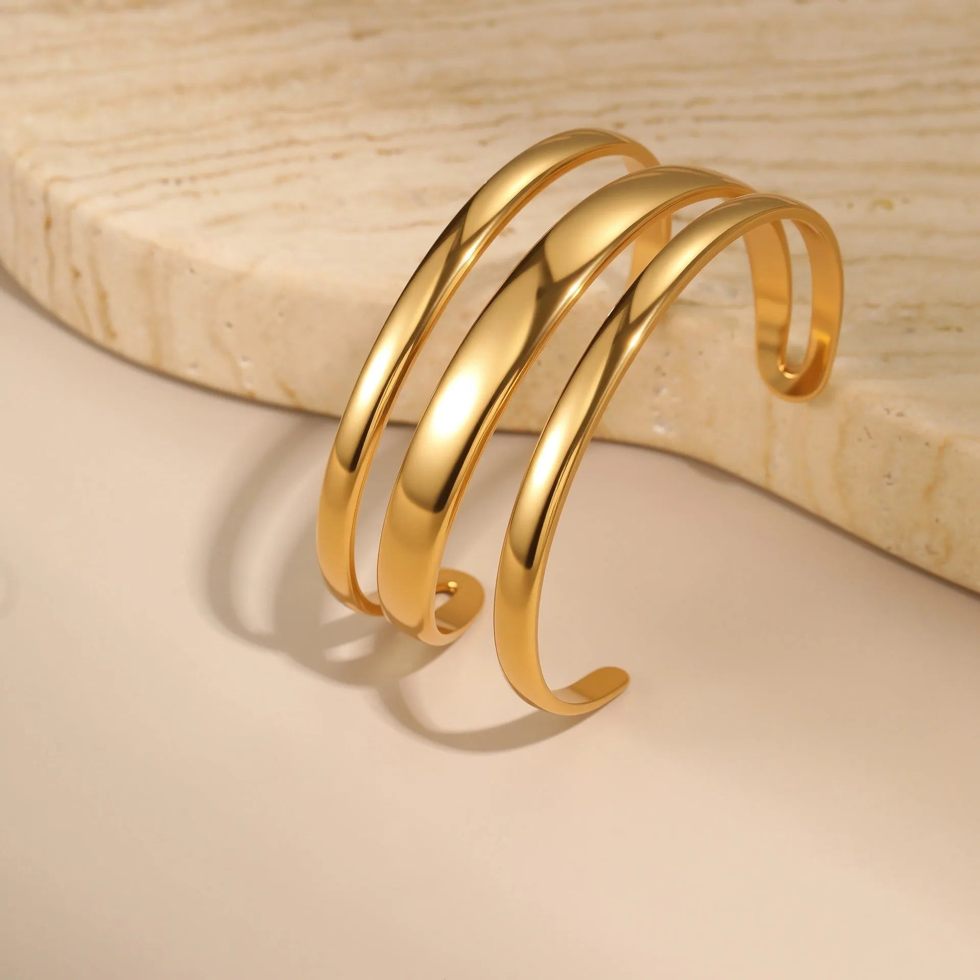 A geometric stainless steel bracelet with a simple opening clasp, shown in a gold electroplated finish.
