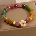Natural colour tourmaline bracelet with floral and fu character charms on geometric electroplated chain