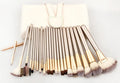 Champagne white synthetic fibre makeup brush set with wooden handles and aluminium ferrules on flat surface