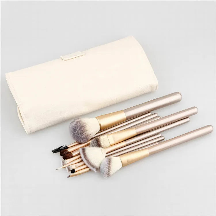 Champagne white synthetic fibre makeup brush set with wooden handles and aluminium ferrules on flat surface